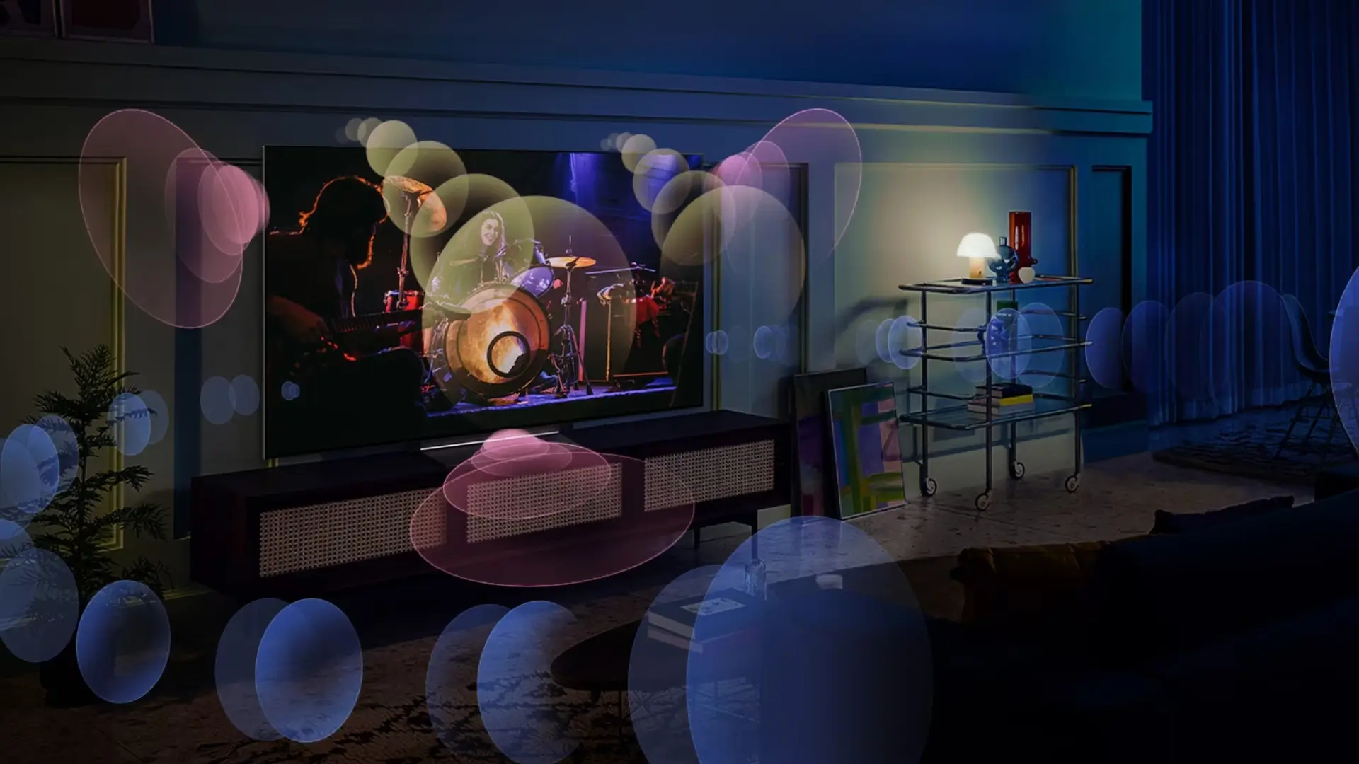 Imagem da TV LG ligada e apoiada em hack com desenhos mostrando por onde sai o som da TV