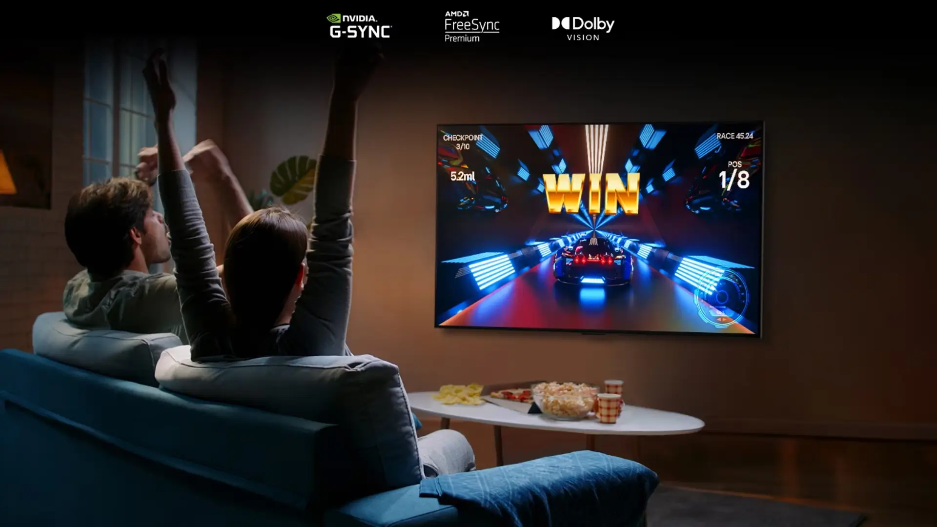 Casal assiste à TV na sala com mesa repleta de aperitivos em frente ao sofá