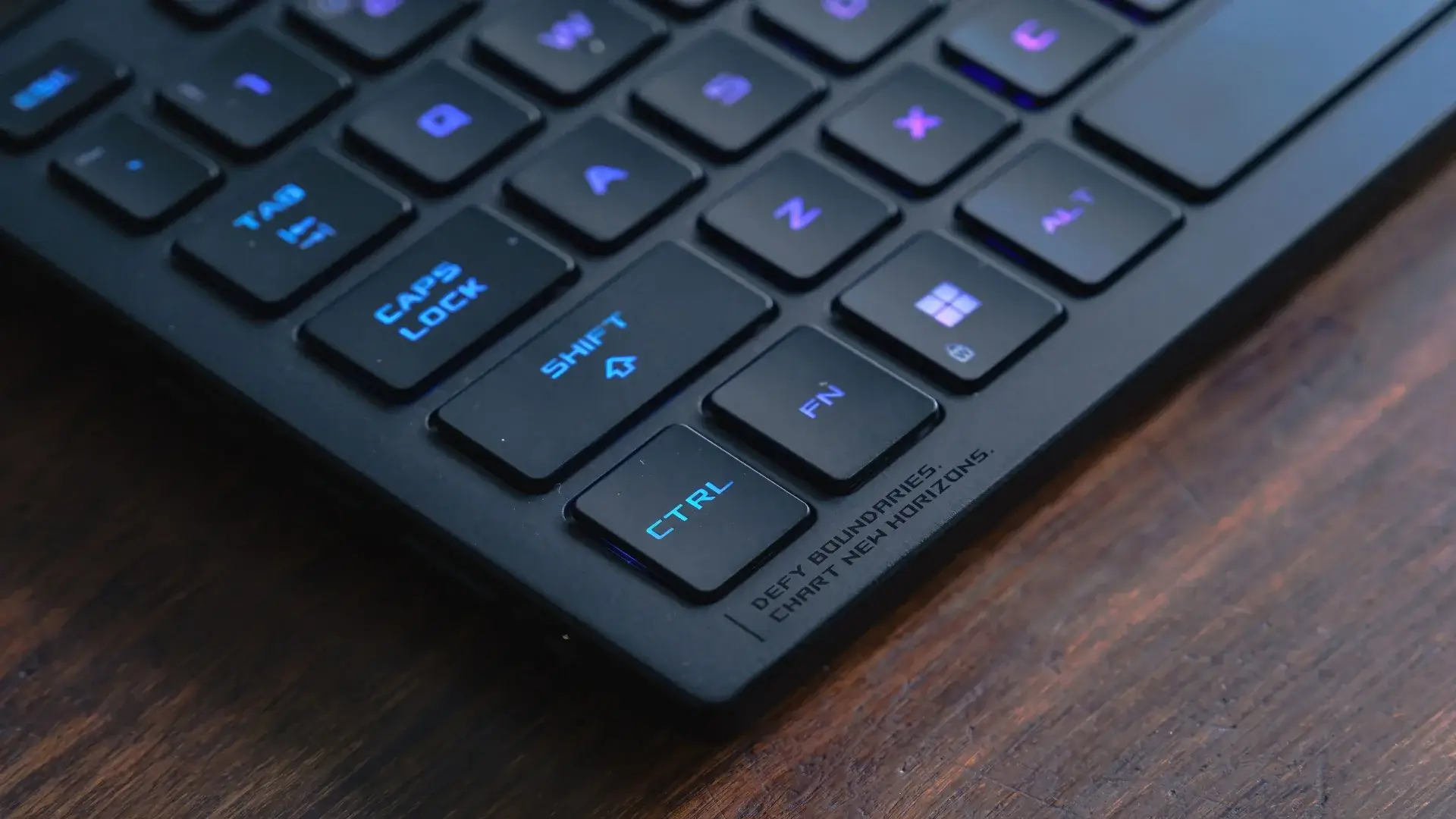 Foto próxima do canto do teclado do Asus ROG Strix G16 com RGB ligado