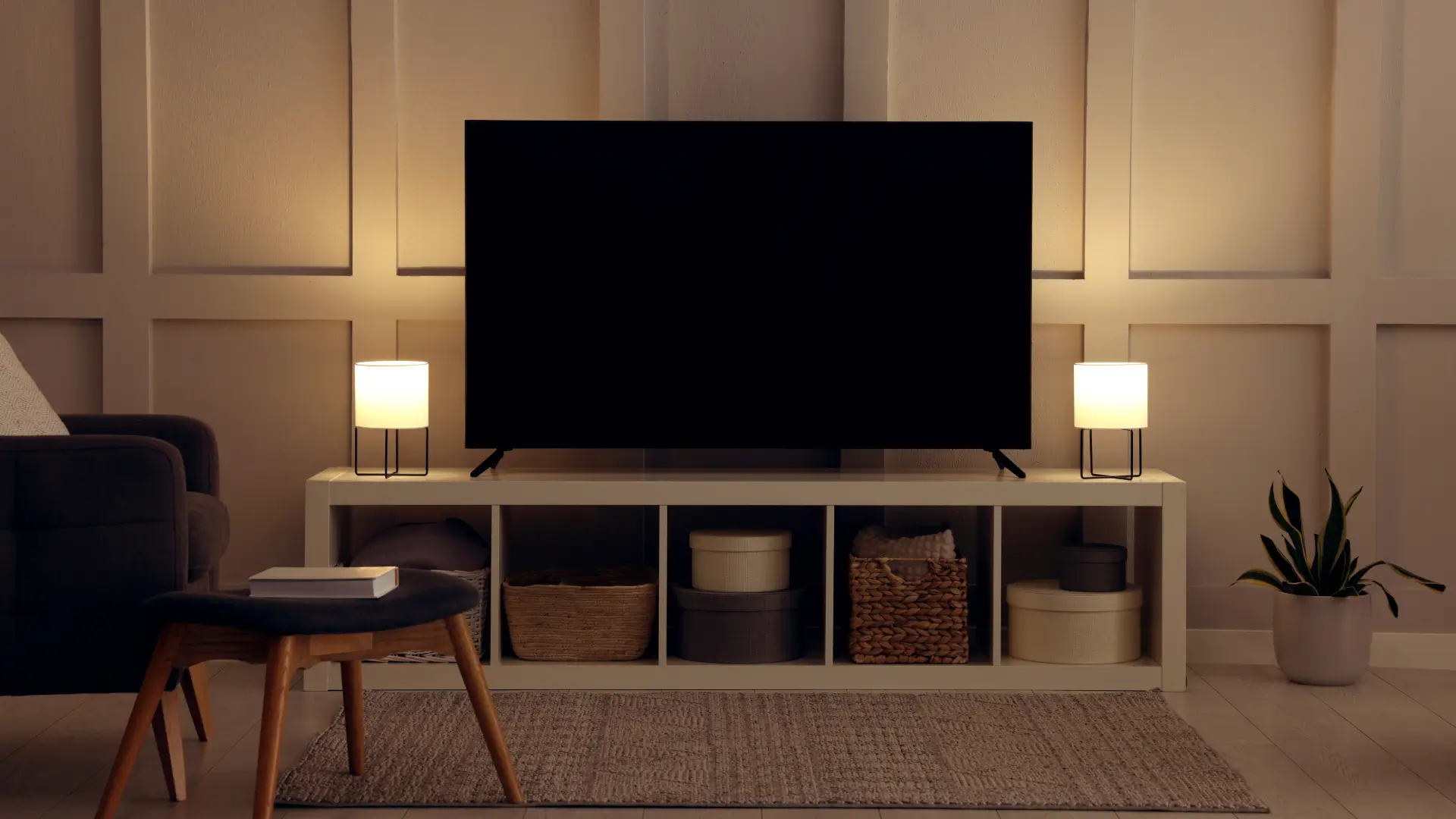 TV desligada e apoiada em hack branco numa sala de estar com tons claros