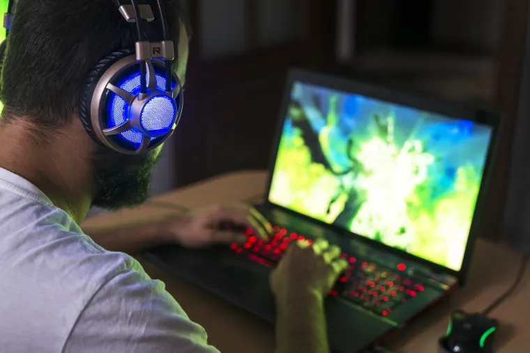 Homem usa notebook gamer para jogar