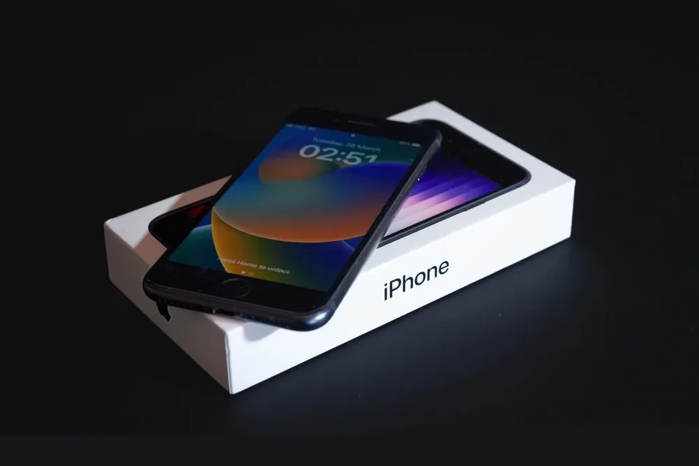  Celular 64GB 4GB RAM iPhone SE 3 sobre a sua caixa em fundo preto