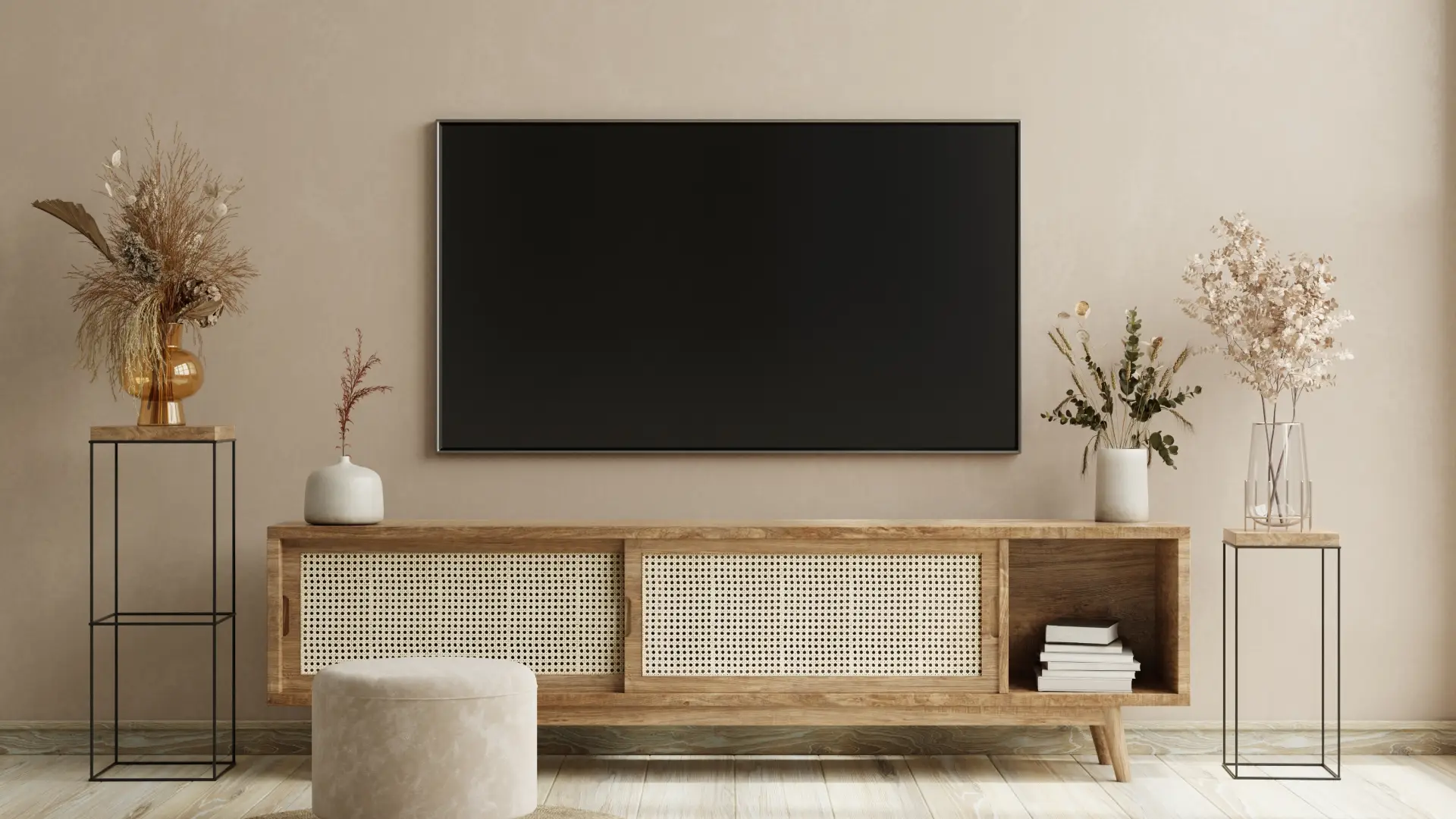 TV desligada pendurada na parede em uma sala com tons nude e neutros