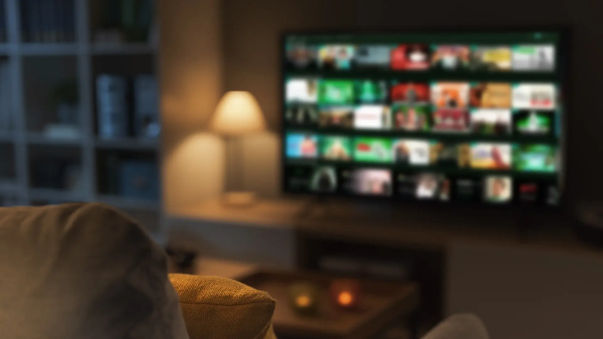 imagem de uma sala de estar, com TV ao  fundo desfocada