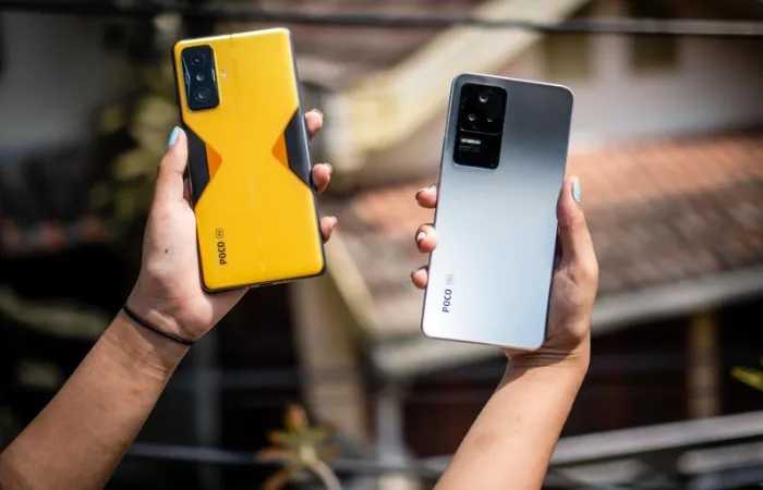 Dois celulares Poco F4 GT de cores diferentes nas mãos de usuário