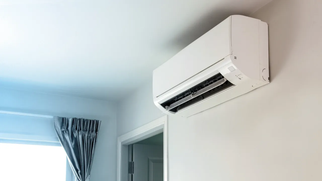 Ar-condicionado split branco em parede branca de quarto