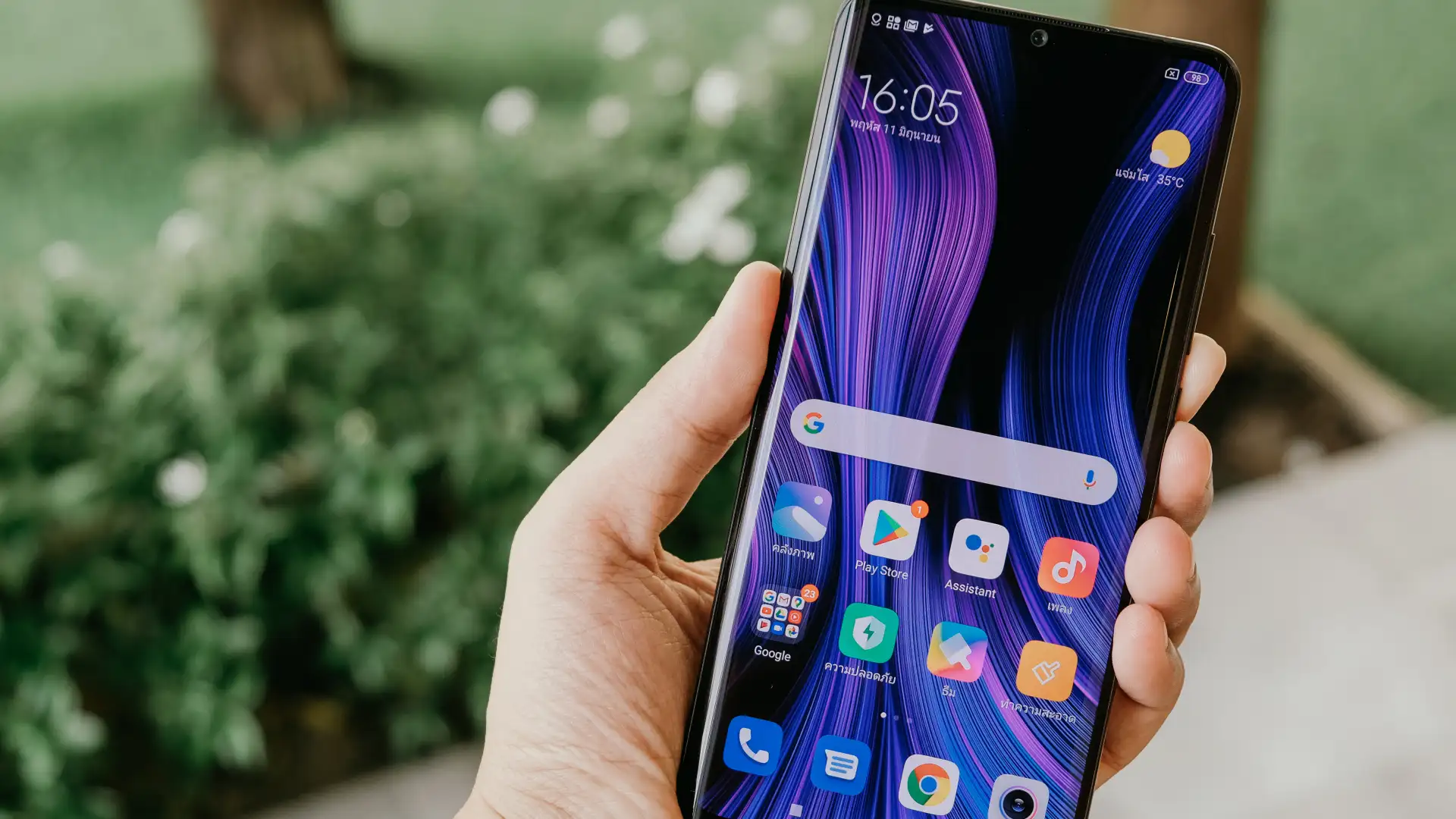 Celular versão global na mão de usuário com fundo desfocado