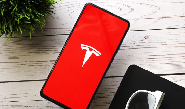 suposto celular tesla sobre mesa de madeira