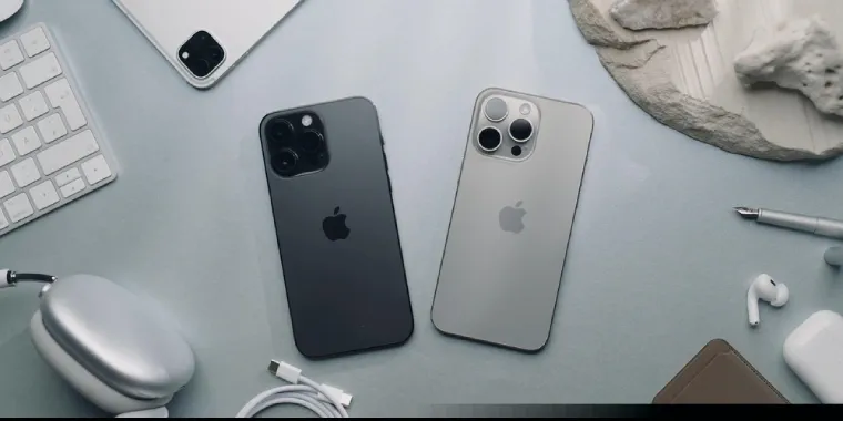 Dois iPhones sobre mesa de escritório com acessórios em volta