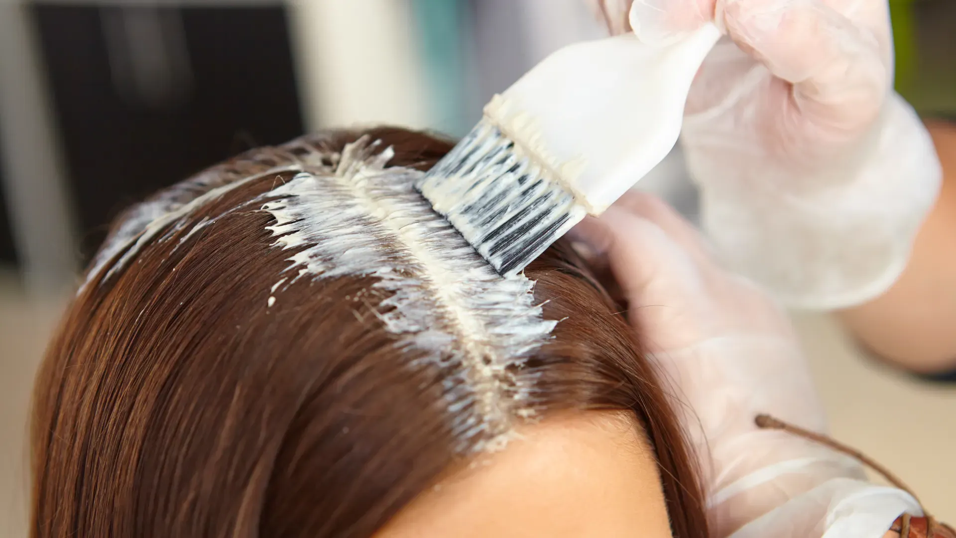 Mulher tendo as raízes do cabelo pintadas