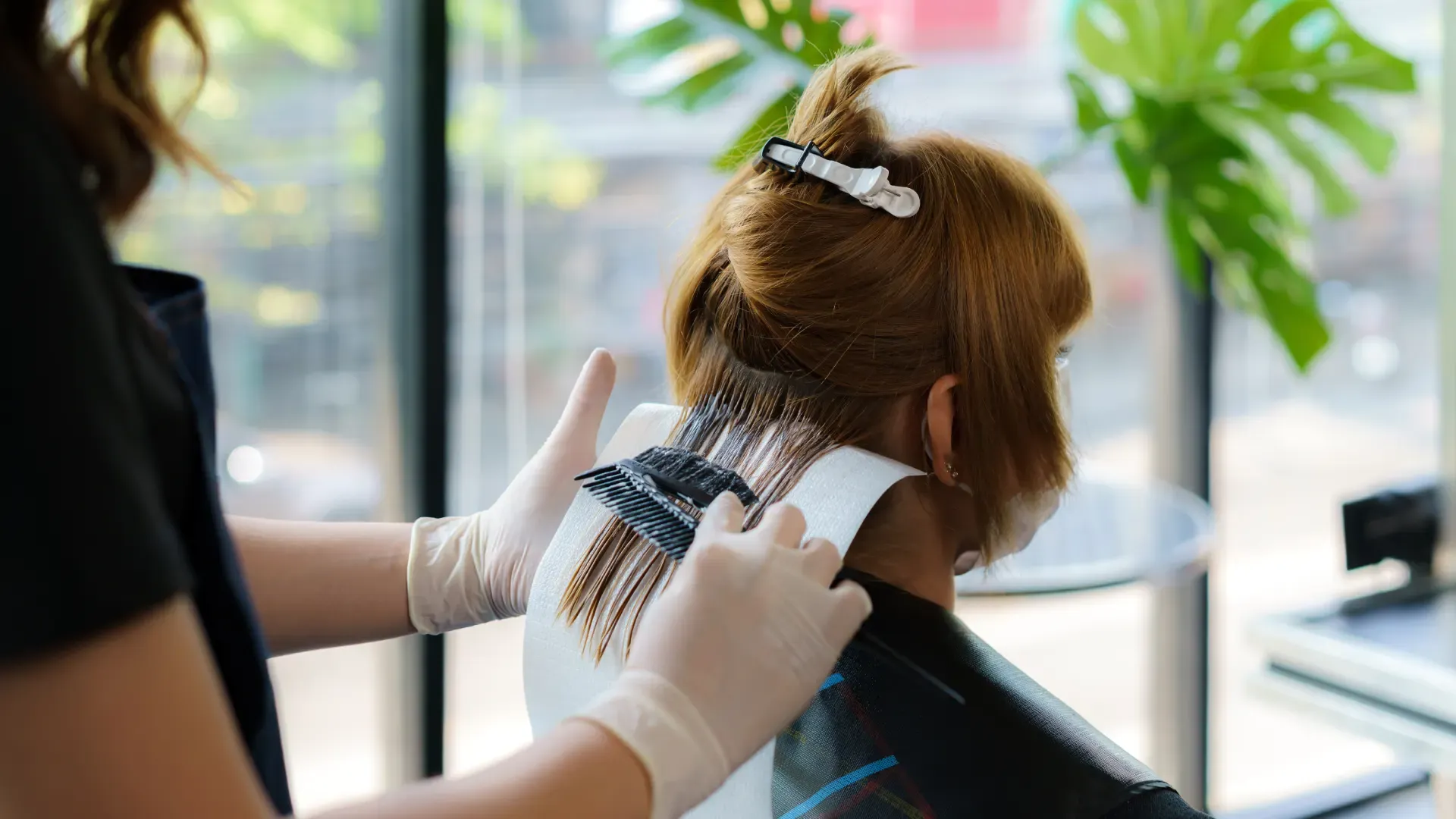 Mulher ruiva tendo seu cabelo pintado em um salão de cabeleireiro