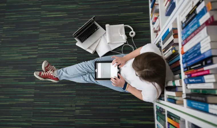 Estudante vista de cima usa tablet para estudar