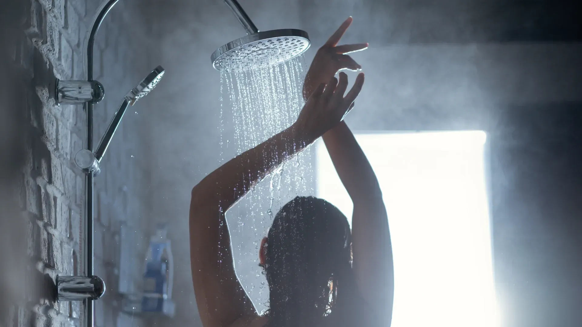 Imagem de uma mulher tomando banho em um chuveiro