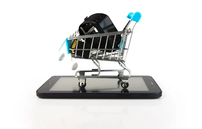 Imagem de um carrinho de compras repleto de gadgets sobre um tablet