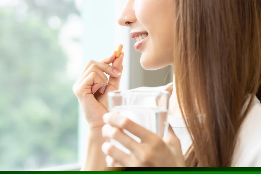 mulher tomando capsula de vitamina para queda de cabelo