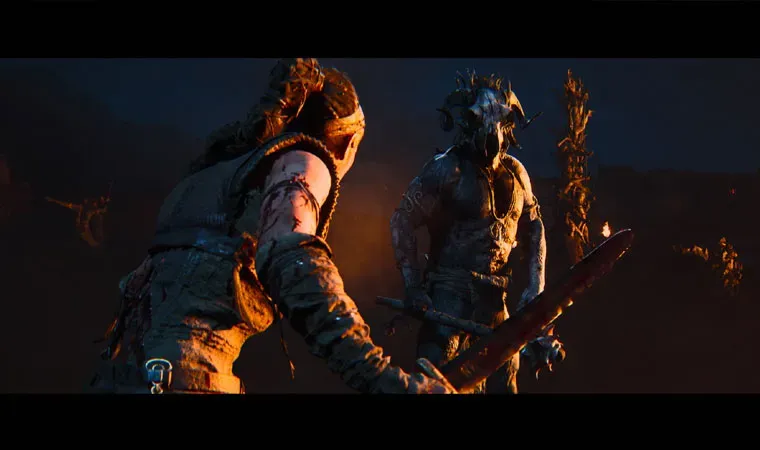 Imagem do jogo Hellblade 2 com a protagonista Senua de costas enquanto segura uma espada para enfrentar um inimigo em um cenário pouco iluminado