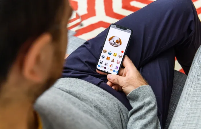Imagem de uma pessoa usando o emoji ‘Memoji” no iPhone