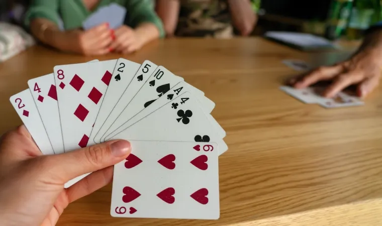Amigos reunidos à mesa jogando baralho