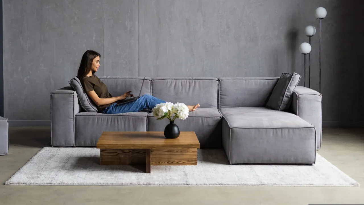 Jovem mulher sentada no sofá trabalhando