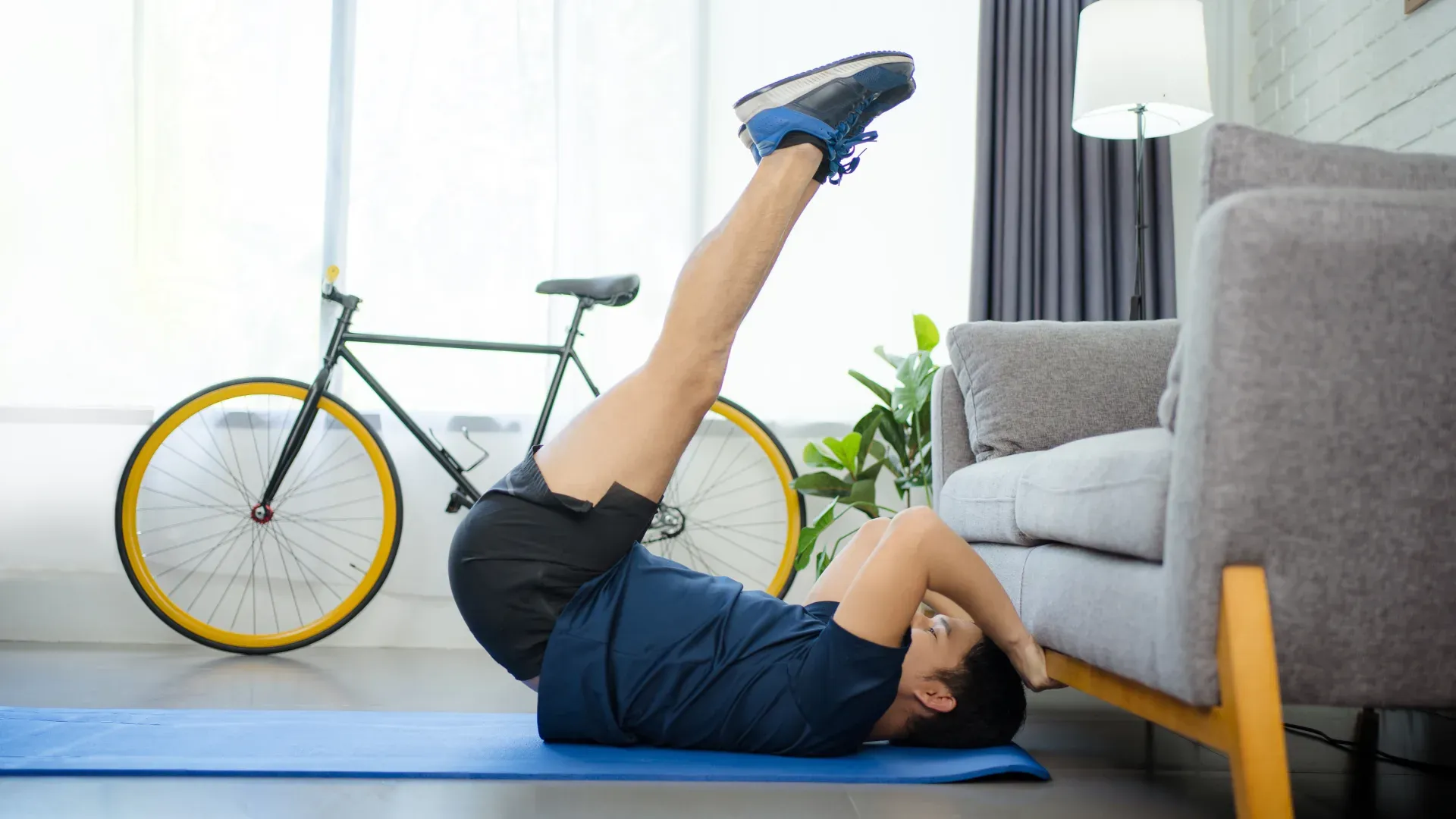 Homem executando abdominal inverso na sala de sua casa