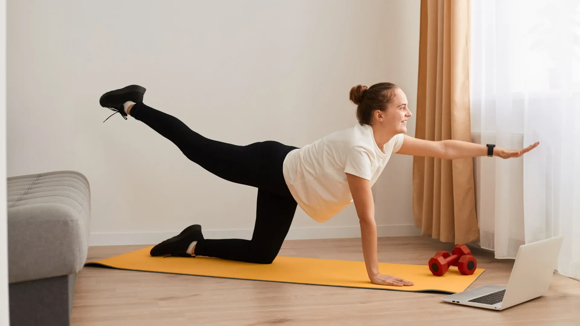 Mulher executa a superman em sala de estar iluminada
