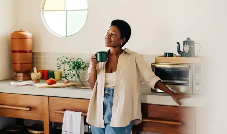 Mulher feliz ao saber como fazer café na cafeteira elétrica.
