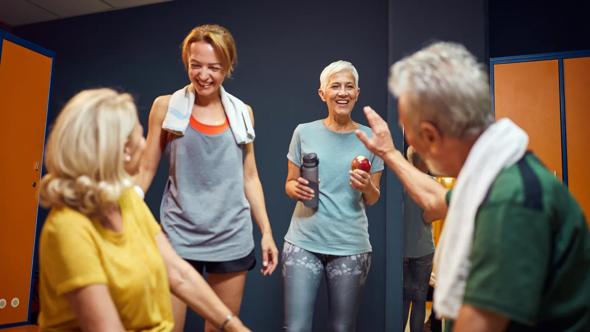 Quatro idosos em vestiário de academia de musculação