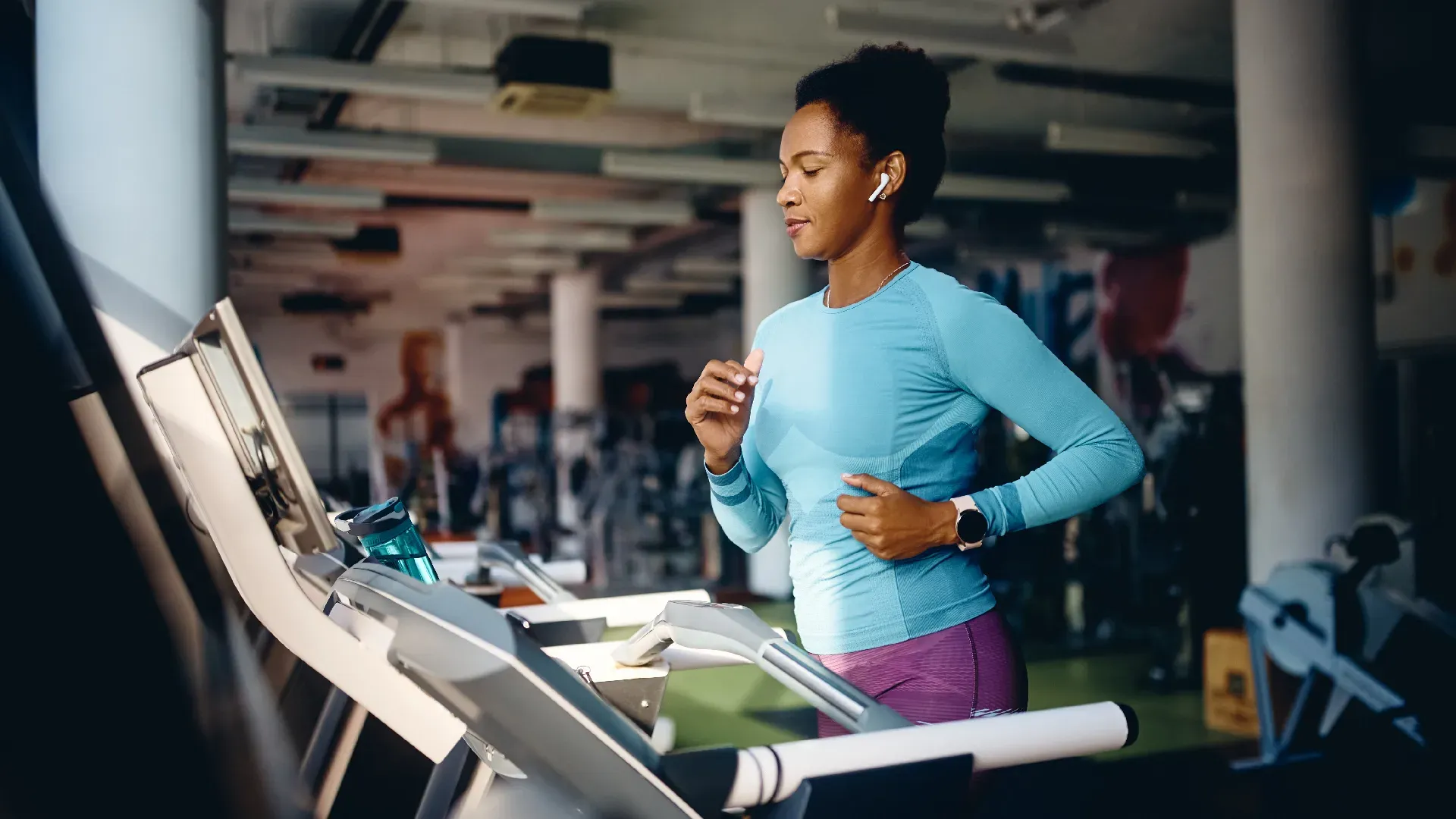 Senhora fazendo treino de cardio em esteira de academia 