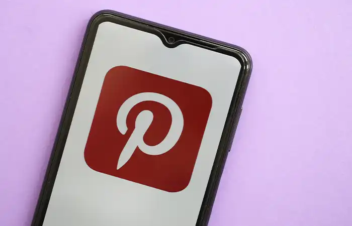 Celular com o aplicativo Pinterest em fundo rosa