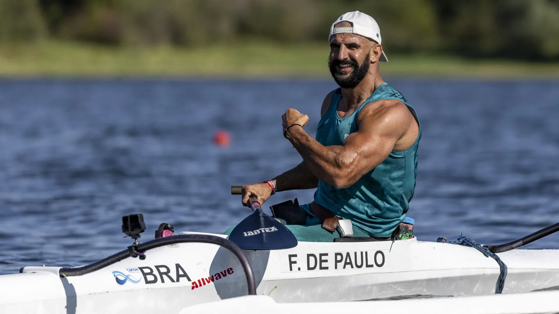 Homem sentado em um caiaque praticando remo no rio à luz do dia