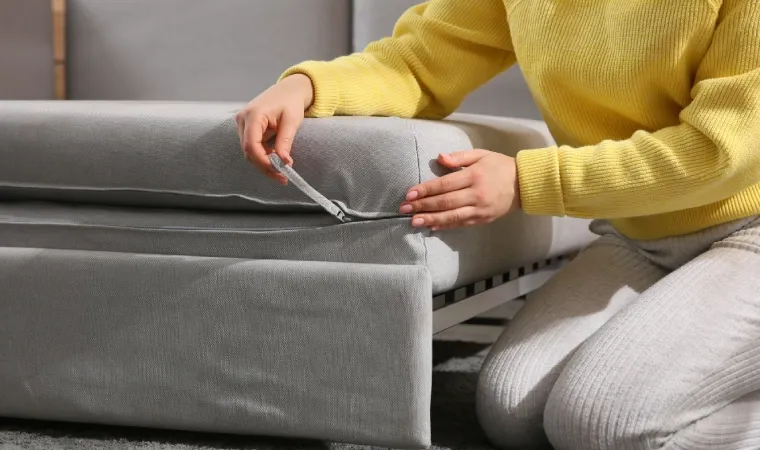 Mulher fechando o zíper de almofada de sofá-cama de solteiro