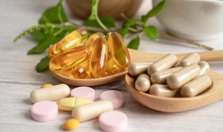 Comprimidos e cápsulas de medicamentos variados em colheres de pau