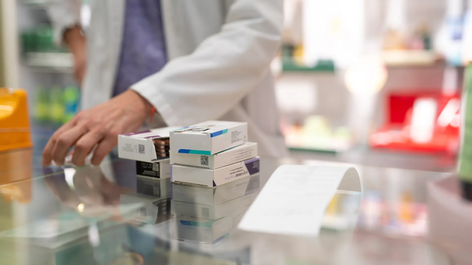 Medicamentos empilhados no balcão da farmácia. 