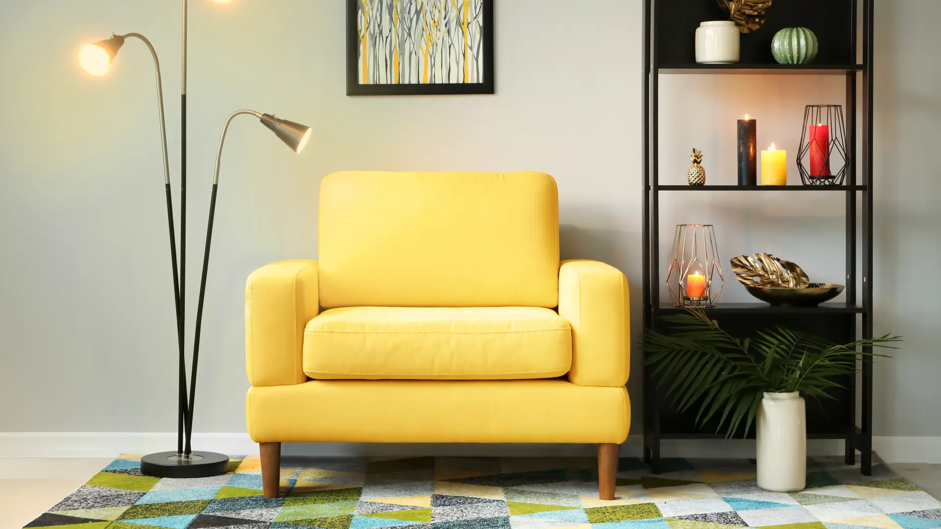 Poltrona amarela em ambiente com estante preta de prateleiras e luminária de piso.