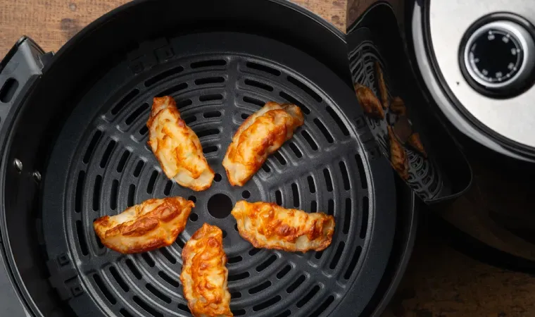 Imagem recomenda opção de airfryer Black Friday com uma air fryer aberta com bolinhos grelhados dentro em destaque.