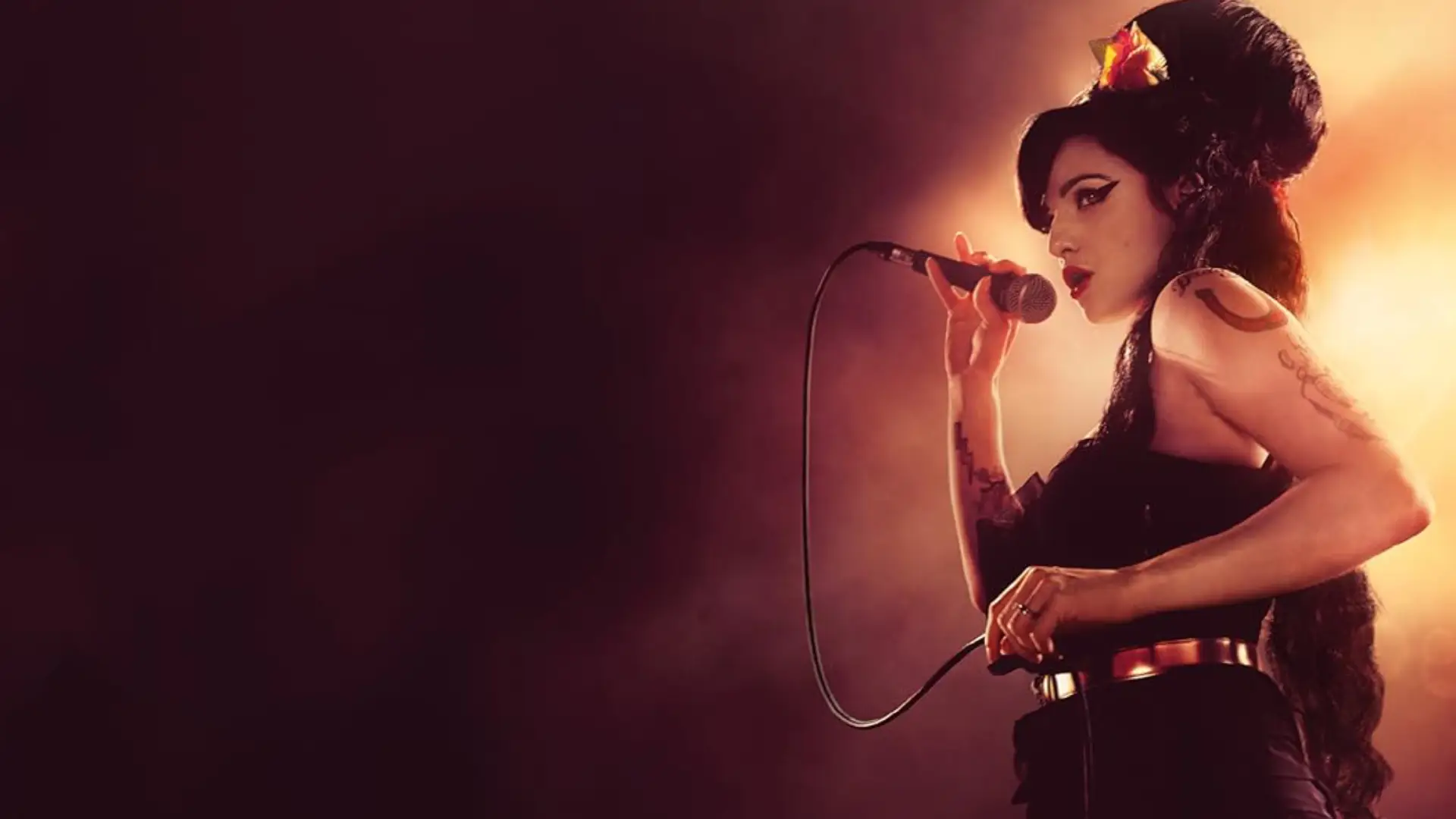 A atriz que interpreta a cantora Amy Winehouse enquanto canta com um fundo vinho e laranja