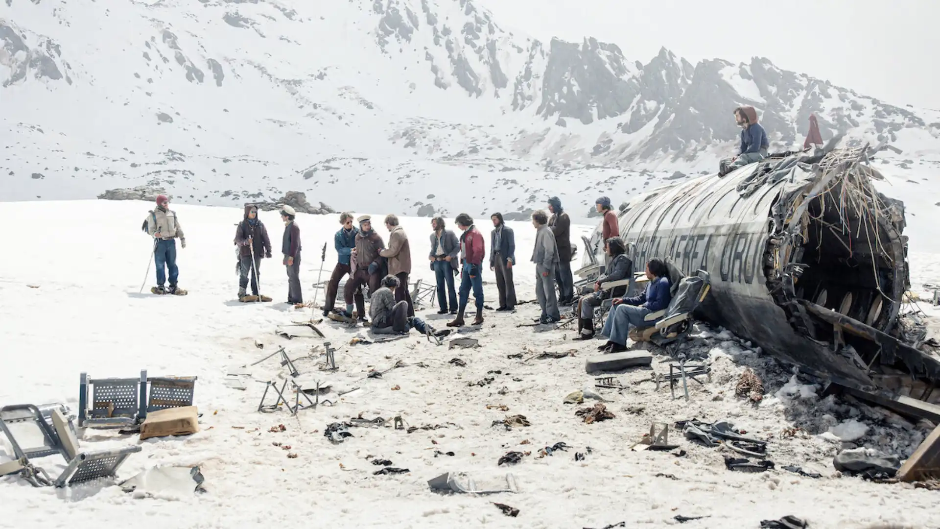 Todos os atores do filme reunidos em uma cena no meio da neve com o avião partido