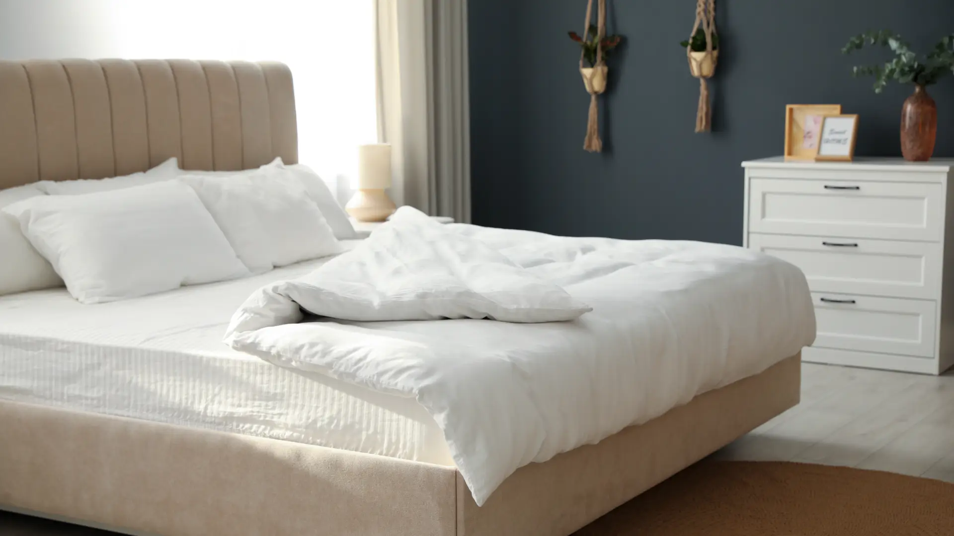 Cama box de acabamento bege e de colchão com lençol e travasseiros brancos