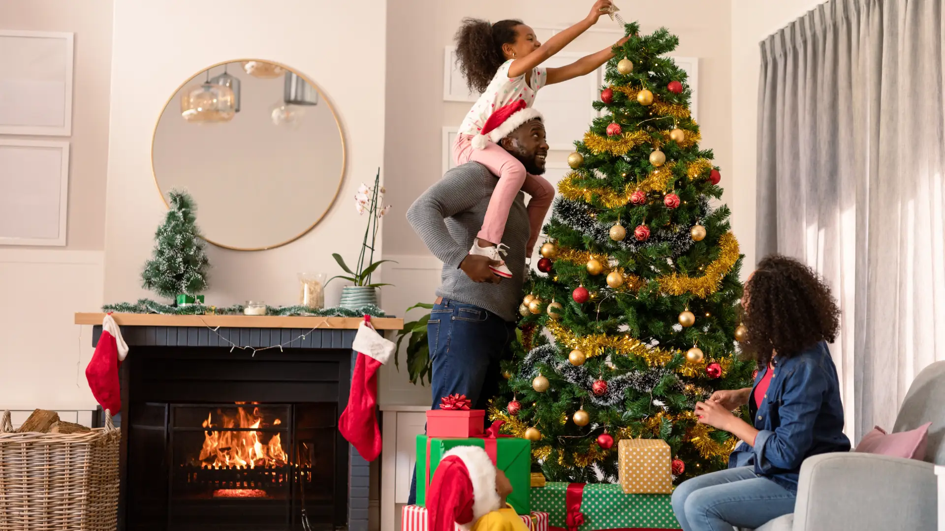 Família reunida finalizando a montagem da árvore de Natal com a estrela 