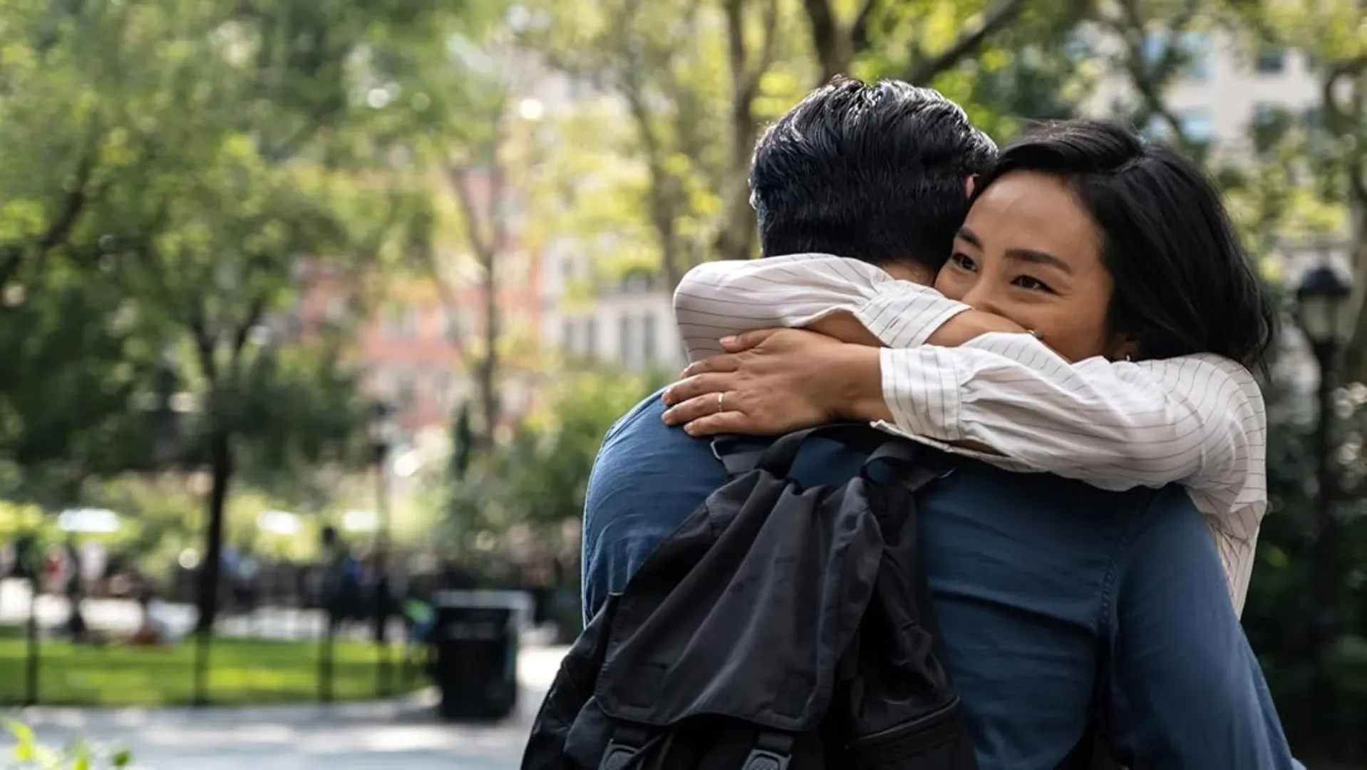 Casal asiático se abraçando em um parque com plantas e árvores