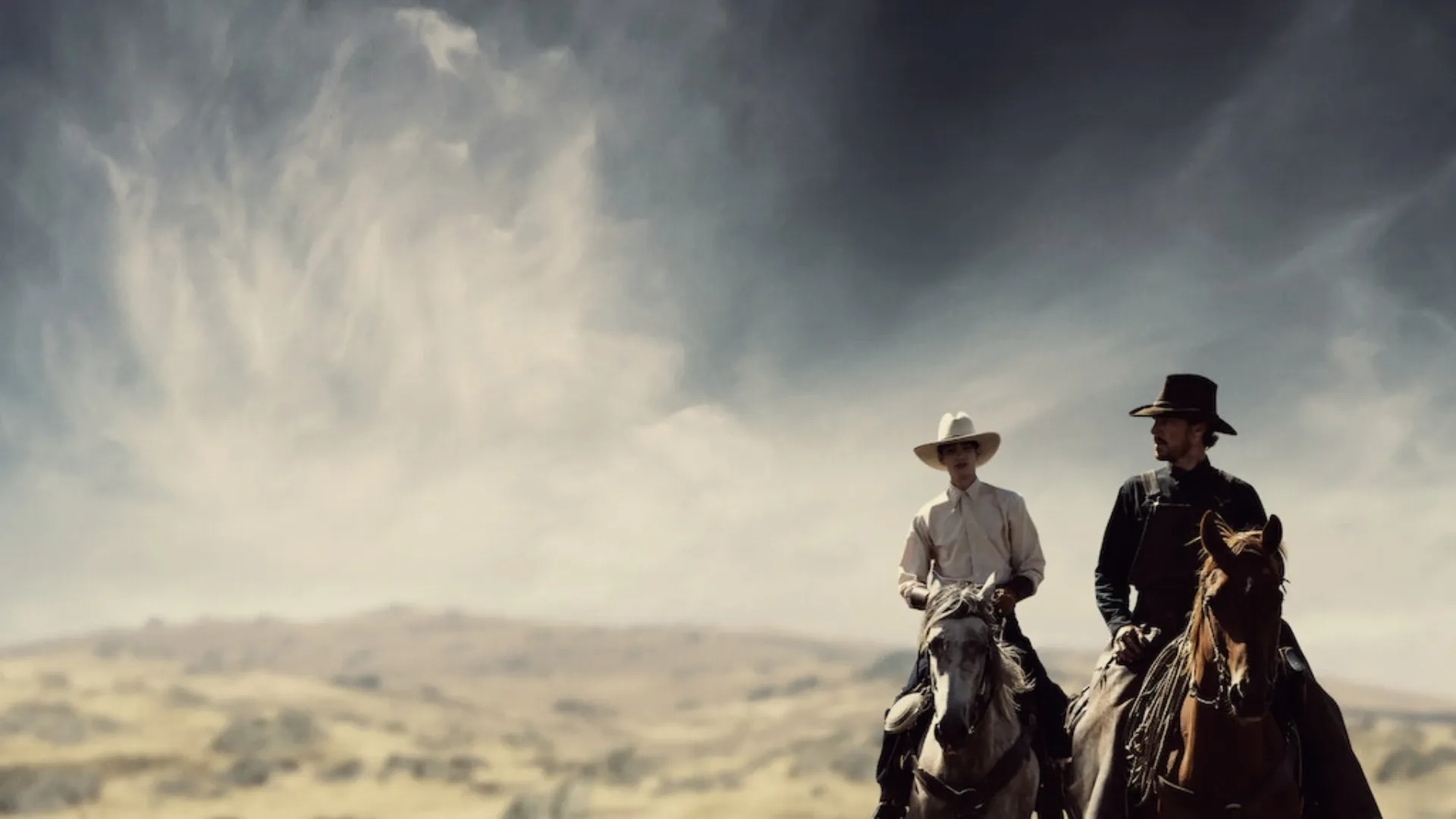 Dois cowboys montados em cavalos com o tempo nublado  