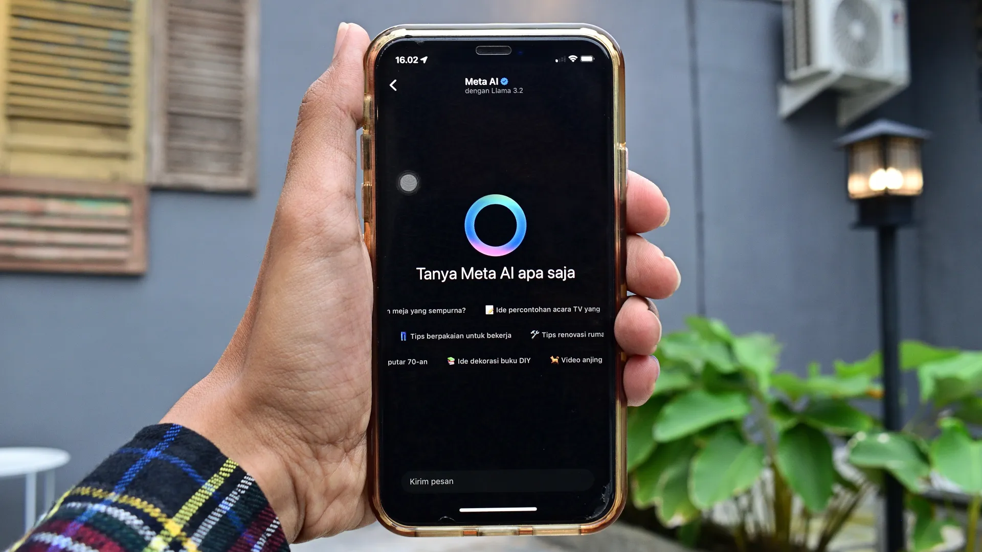 Imagem de uma mão segurando um celular na página da inteligência Meta AI