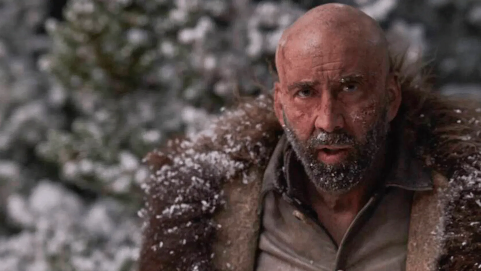 Homem barbudo com neve espalhada pelo rosto com um casacão de pelo