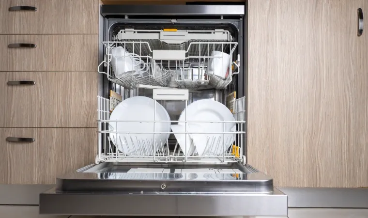 Máquina lava-louça aberta com louças organizadas dentro.