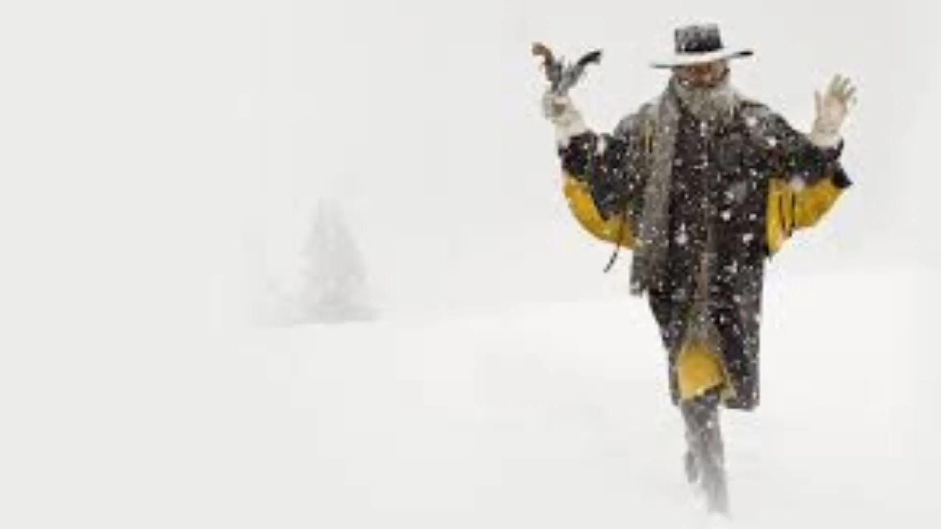 Homem em uma nevasca, vestindo casaco preto com amarelo, chapéu preto e cachecol cinza, segurando uma arma decorativa com fundo branco enevoado. 