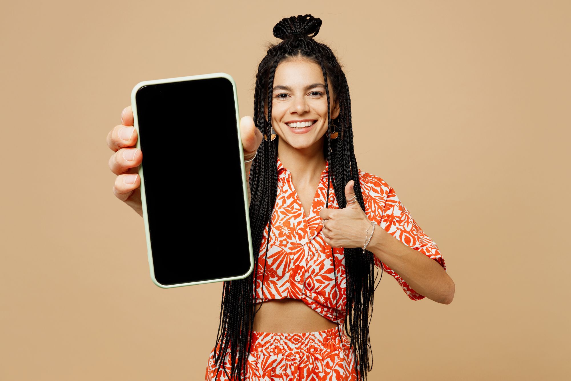 Mulher segurando um celular até 600 reais em fundo laranja