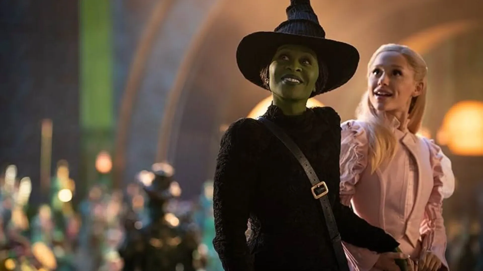 Elphaba e Glinda olhando para a cidade de Esmeraldas, com expressões impressionadas