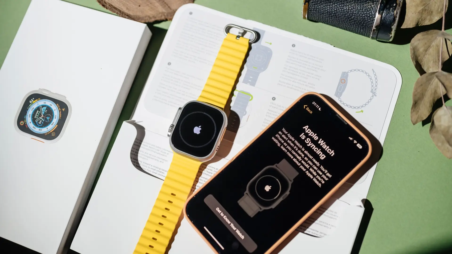 Imagem de um Apple Watch sendo pareado com um iPhone, ambos em cima da caixa do Apple Watch
