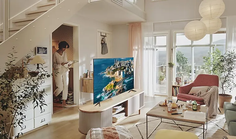 Sala moderna com TV CU7700, sofá rosa, mesa de centro e plantas decorativas.