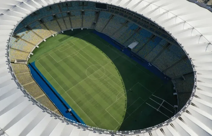 Foto aérea do estádio do Maracanã, com gramado parcialmente coberto pelo sol